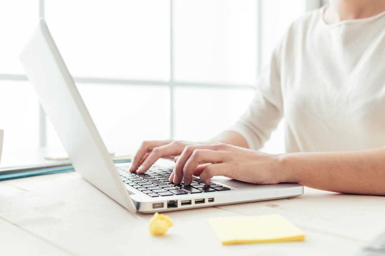 woman on computer completing net metering application to switch to solar energy