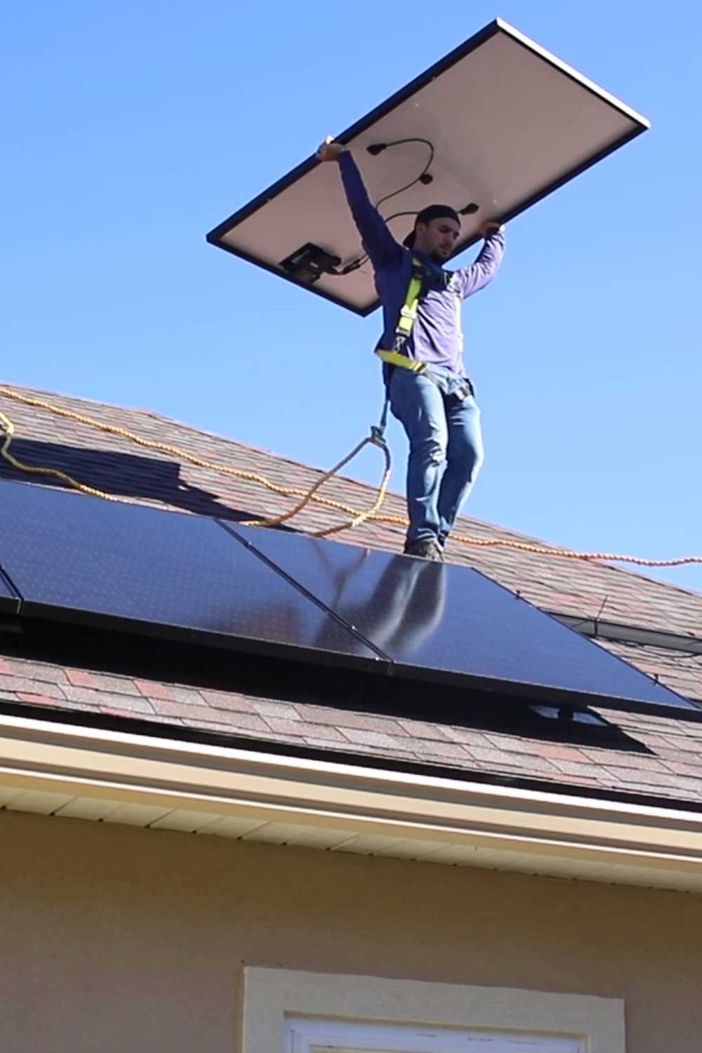 solar installer carrying rooftop solar panel when installing home energy system