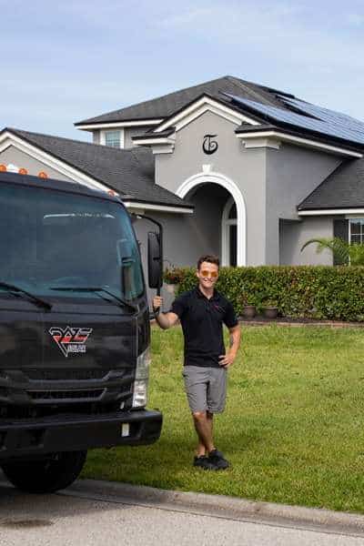 Florida solar installer outside of home with rooftop solar panels