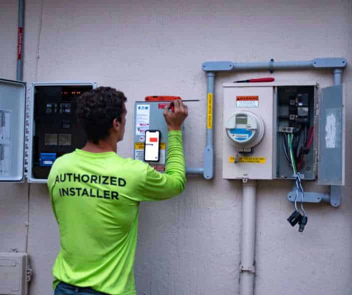 solar installer connecting solar panels to energy meter outside home