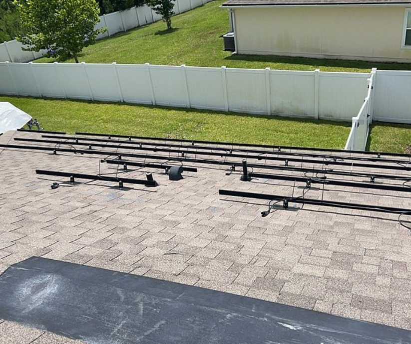 solar panel mounting brackets being installed on residential shingle roof