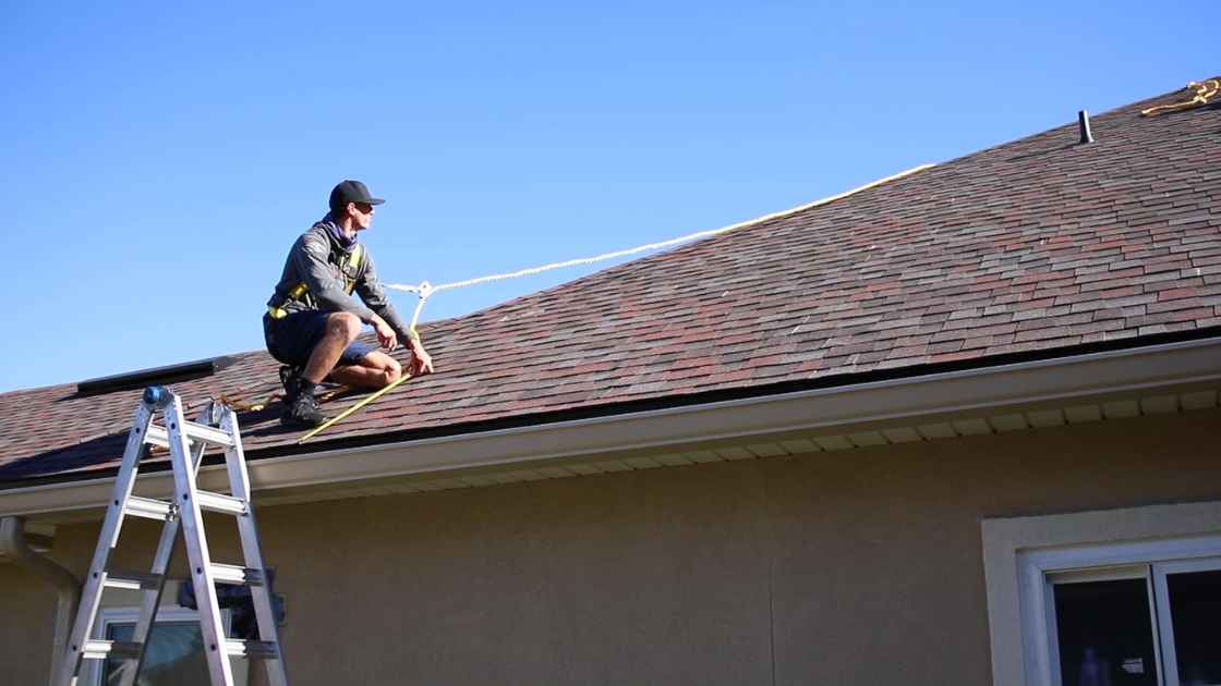 solar energy installer on roof of home providing quote for new energy system