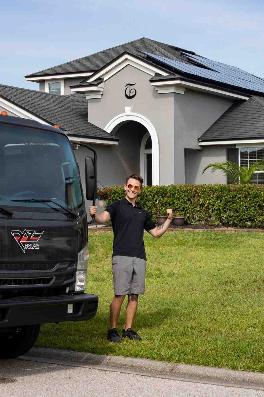 Company rep of Raze Solar standing outside of home after Florida solar panels have been installed on roof